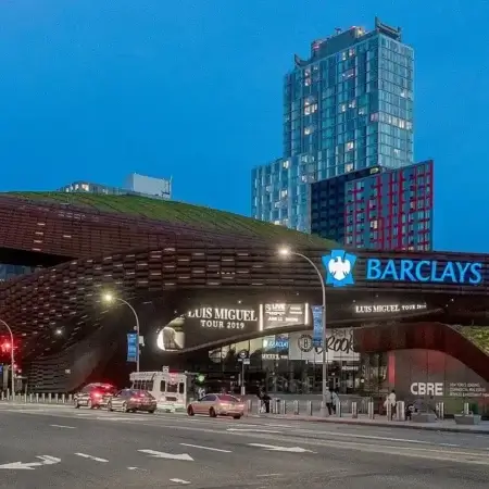Façade futuriste du Barclays Center illuminée à la tombée de la nuit à Brooklyn
