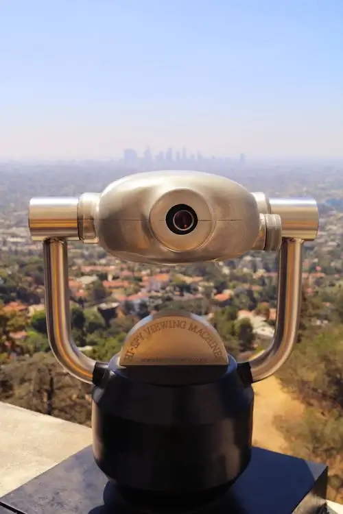 Catalejo instalado en una terraza del Griffith Observatory, con vista de Los Ángeles de fondo