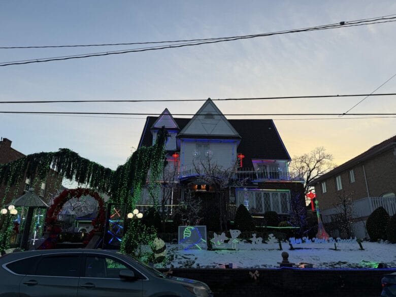 Casa iluminada en Dyker Heights con guirnaldas verdes y personajes luminosos