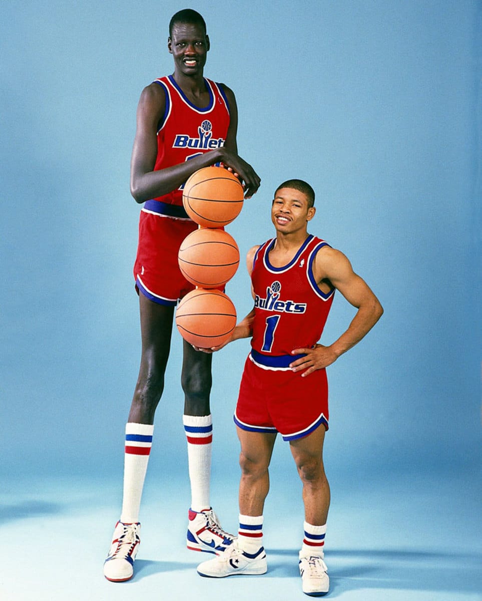 Manute Bol y Muggsy Bogues posan juntos con la equipación de los Bullets