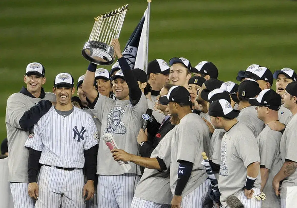 El capitán de los Yankees, Alex Rodriguez, levanta el Trofeo del Comisionado rodeado de sus compañeros de equipo tras la victoria en la Serie Mundial de 2009