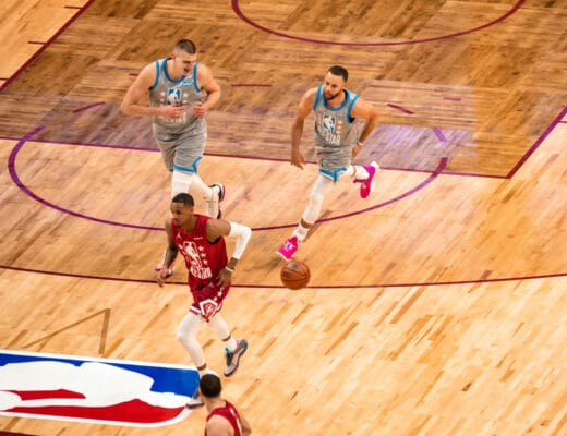 Nikola Jokić y Stephen Curry esprintan con camisetas grises del Team LeBron durante un contraataque en el NBA All-Star Game 2022 en Cleveland
