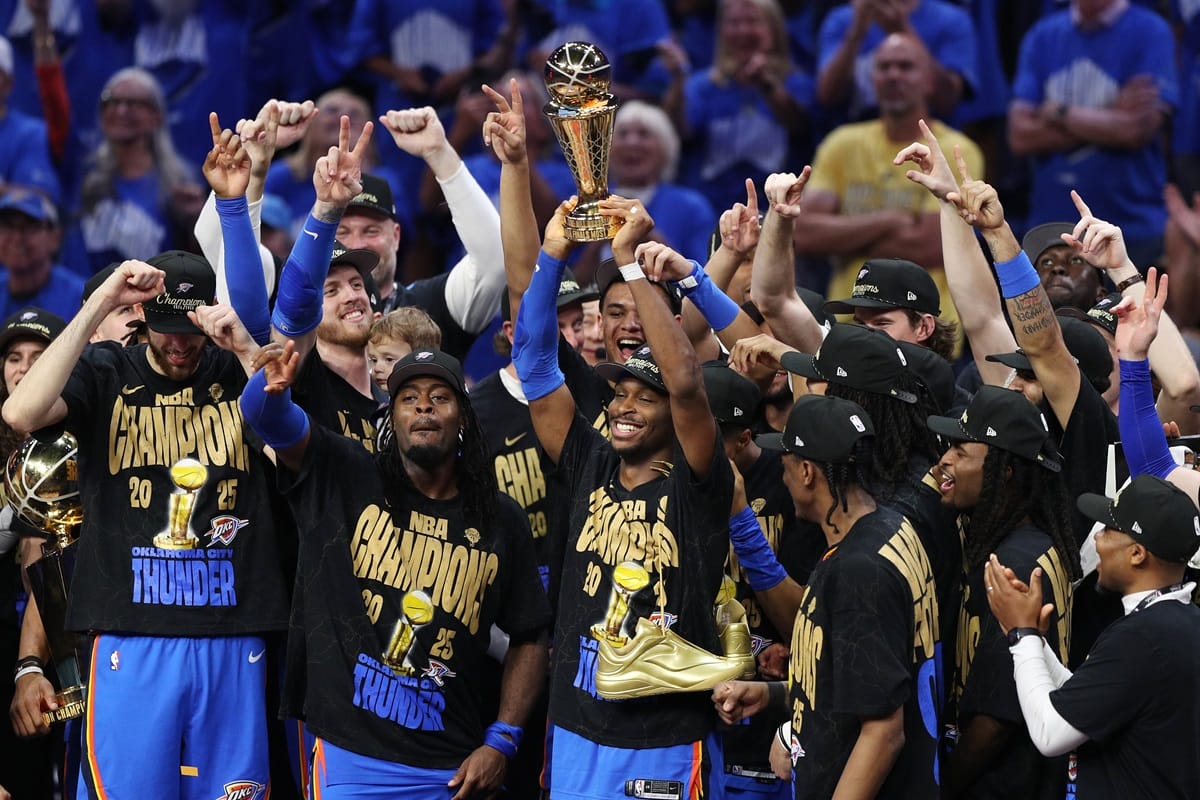 Les joueurs de l’Oklahoma City Thunder célèbrent leur titre NBA 2025 en brandissant le trophée sur le parquet