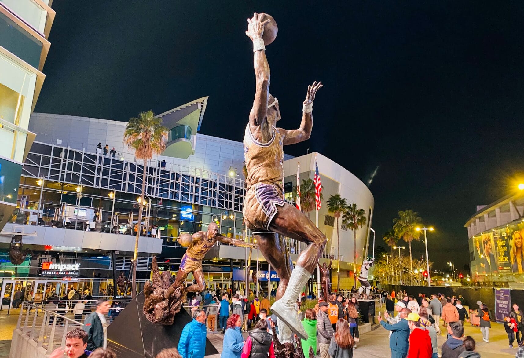Statues des légendes des Los Angeles Lakers devant la Crypto.com Arena, de nuit