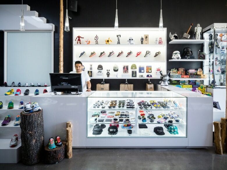 Interior de BAIT Melrose en Los Angeles, con sneakers, vitrinas de accesorios, figuras coleccionables y productos de cultura pop.