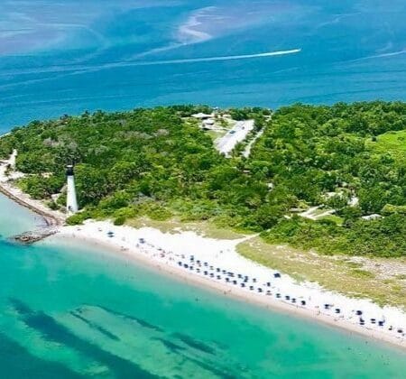 Vista aérea de Bill Baggs Cape Florida State Park y el Cape Florida Lighthouse en Key Biscayne, Florida, con sus playas de arena blanca y aguas turquesas.