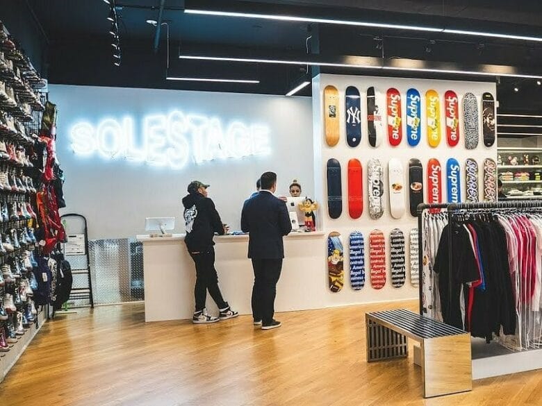 Interior de SoleStage Fairfax en Los Angeles, con pared de sneakers, ropa streetwear y tablas de skate decorativas.