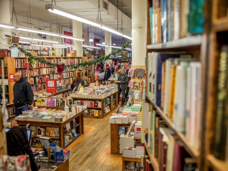 Interior de una librería independiente en Nueva York con estanterías llenas de libros y mesas de novedades.