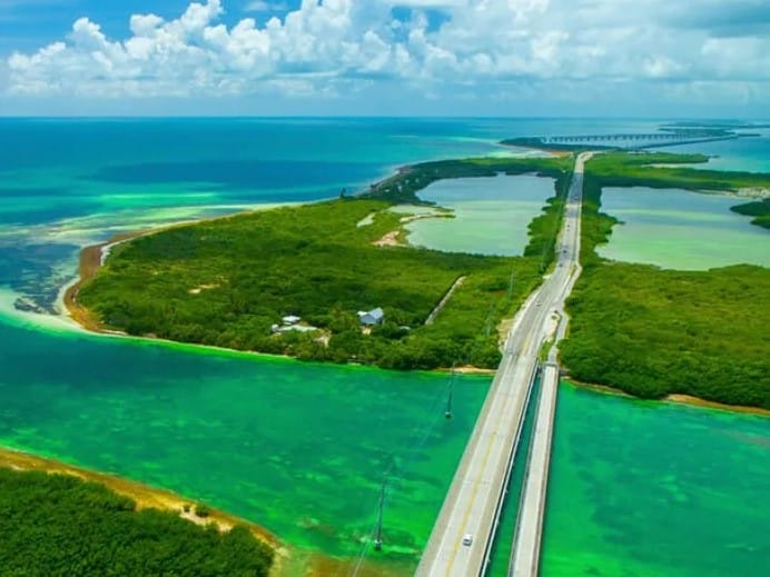 Vista aérea del Rickenbacker Causeway, la carretera que conecta Miami con Virginia Key y Key Biscayne, rodeada por las aguas turquesas de la Bahía de Biscayne.