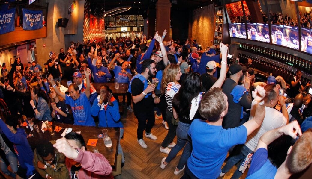 Fans des New York Knicks en liesse dans un sports bar pendant un match de playoffs