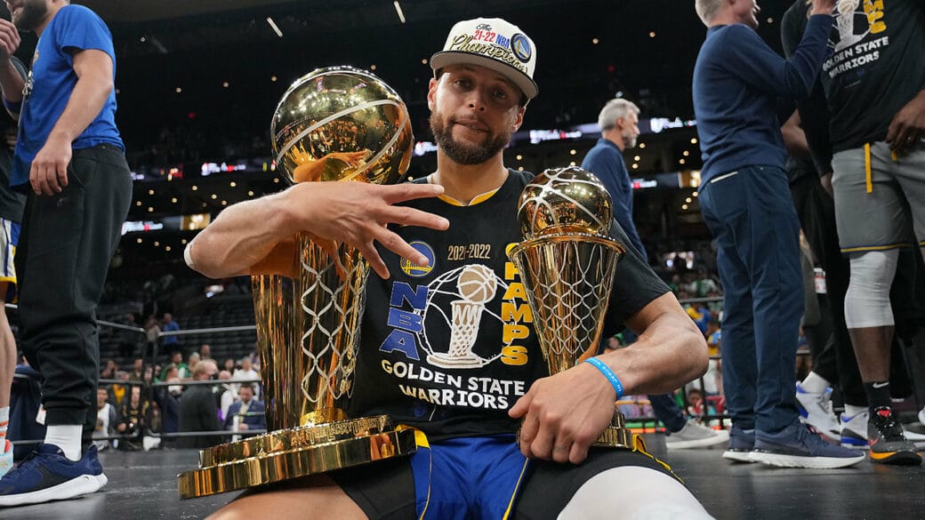 Stephen Curry posant avec le trophée NBA et le MVP des Finales 2022
