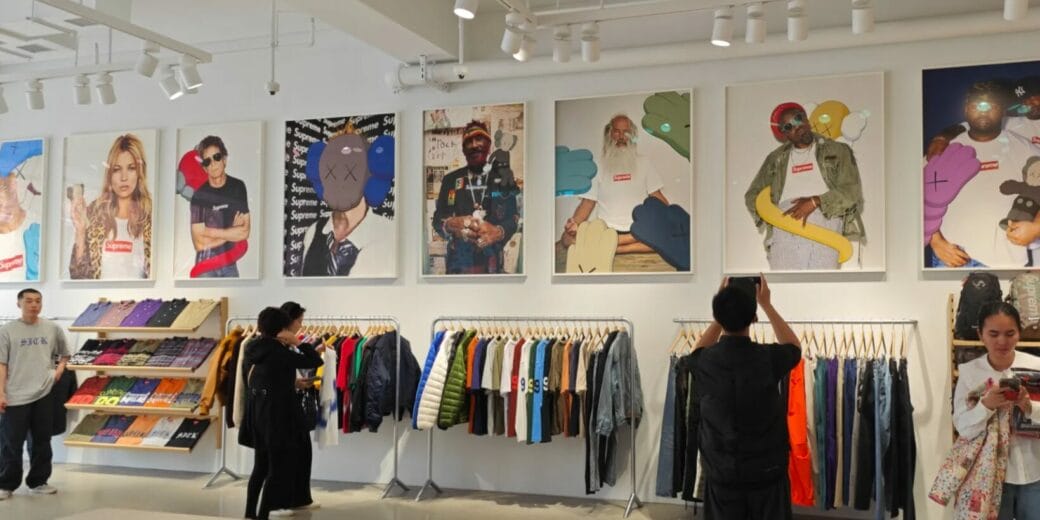 Interior de una tienda streetwear en Nueva York con ropa urbana, camisetas y arte Supreme en la pared.