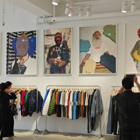 Interior de una tienda streetwear en Nueva York con ropa urbana, camisetas y arte Supreme en la pared.